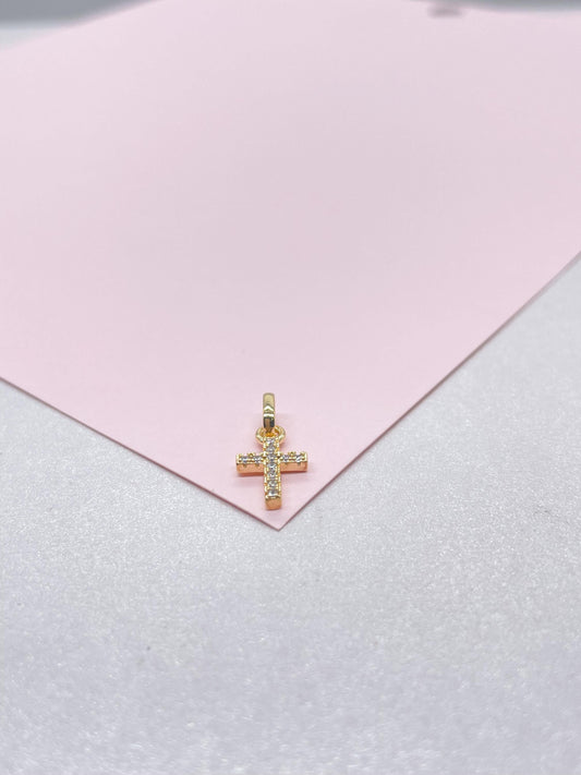 May include: A small gold cross pendant with clear sparkling stones.